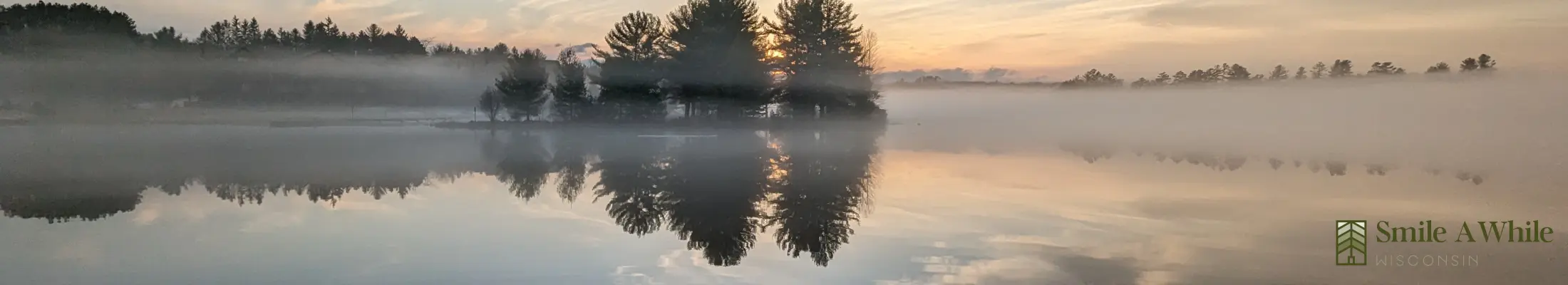 Stunning lakefront view from Smile Awhile vacation rental in Eagle River, WI, showing calm waters and Northwoods scenery.