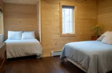 Bedroom interior at Smile Awhile, featuring bedside lamps, USB charging ports, and modern convenience.