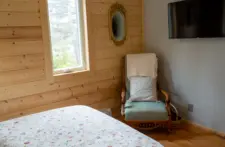 Sun-drenched bedroom with large windows overlooking the lakefront property in Eagle River.