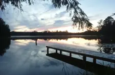 Peaceful morning lake view from the deck at Smile Awhile vacation rental in Eagle River, WI, perfect for coffee and relaxation.