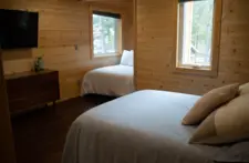 Bedroom window view showing the beautiful Eagle River pine trees and scenic landscape.