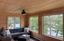Second-floor living area at Smile Awhile in Eagle River, WI, featuring elevated panoramic views of the lake and pine trees.