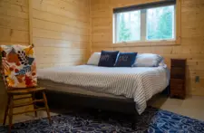 Spacious master bedroom at Smile Awhile in Eagle River, WI, featuring a comfortable king-size bed and forest views.
